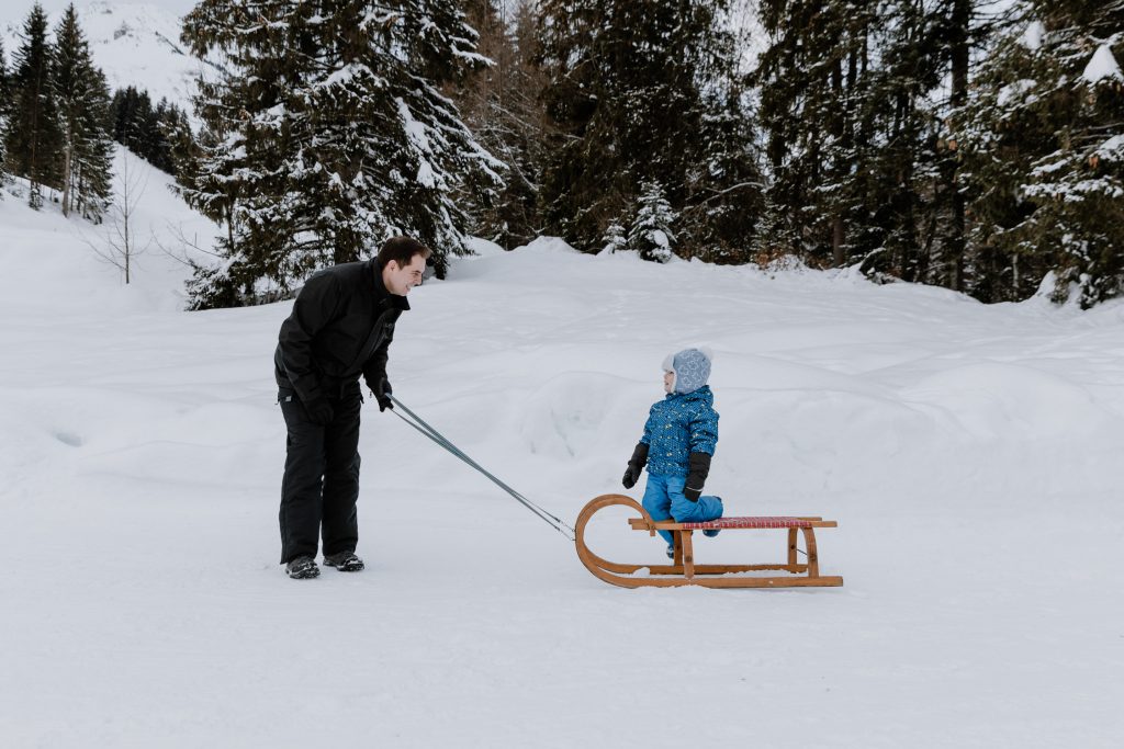 Natürliche Familienfotos in der Natur, Schnee, Rodel