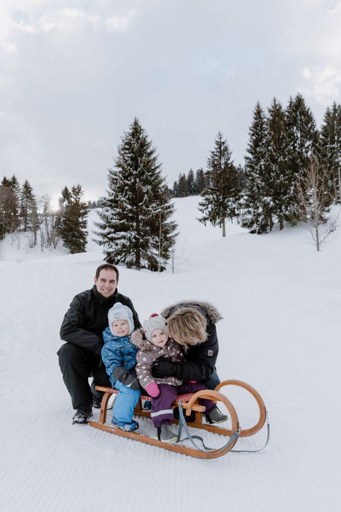 Natürliche Familienfotos in der Natur, Schnee, Rodel