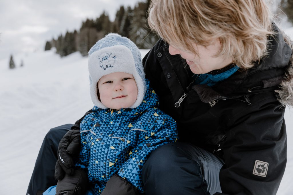 Natürliche Familienfotos in der Natur, Schnee, Rodel, Mama und Sohn