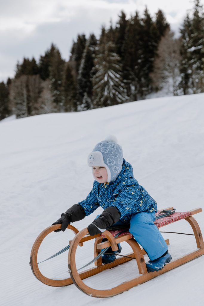 Natürliche Familienfotos in der Natur, Schnee, Rodel