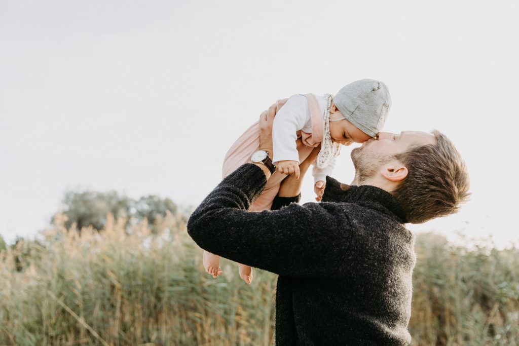 Familienfotos: Papa hebt Kind in die Luft