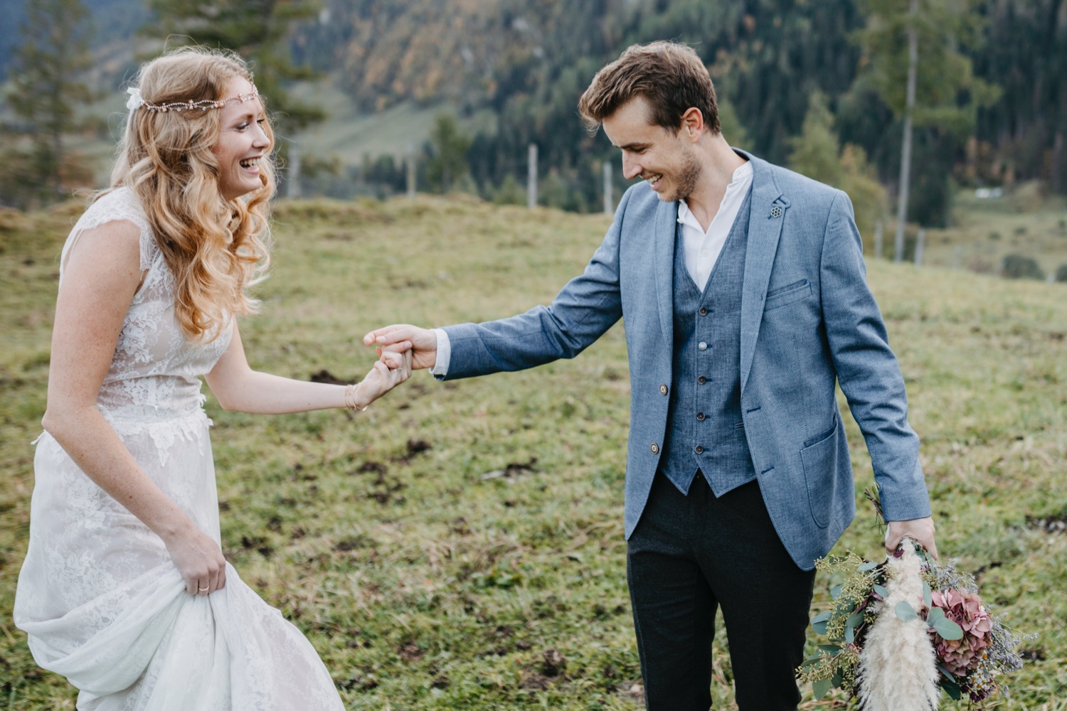 lachendes, tanzendes Brauptaar in den Bergen